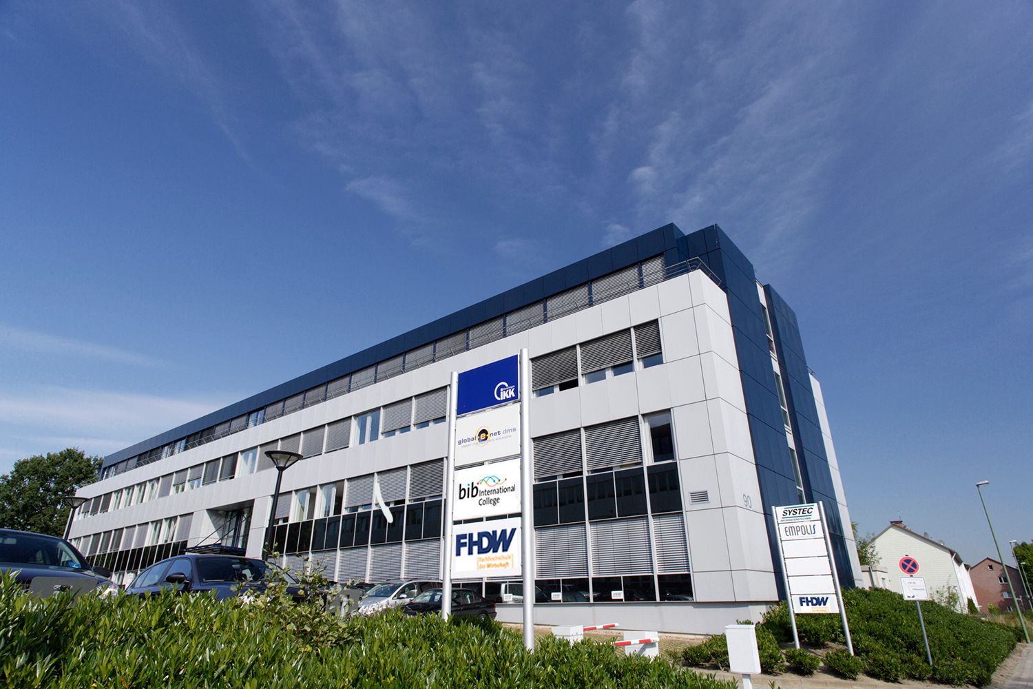 Gebäude der FHDW in Bielefeld mit FHDW-Schild im Vordergrund