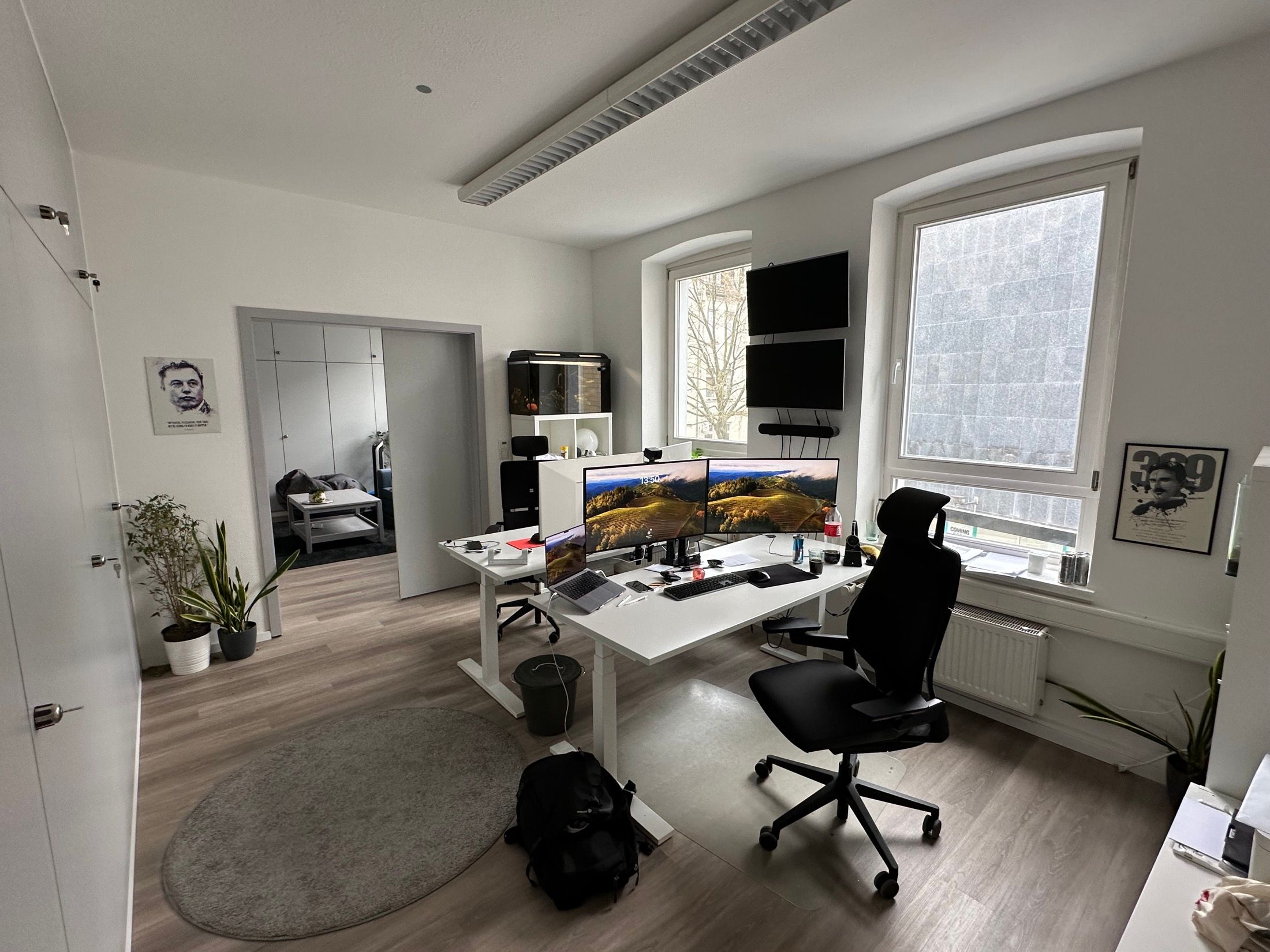 Heller Arbeitsraum mit Ultrawide-Monitoren, Pflanzen und höhenverstellbaren Tischen